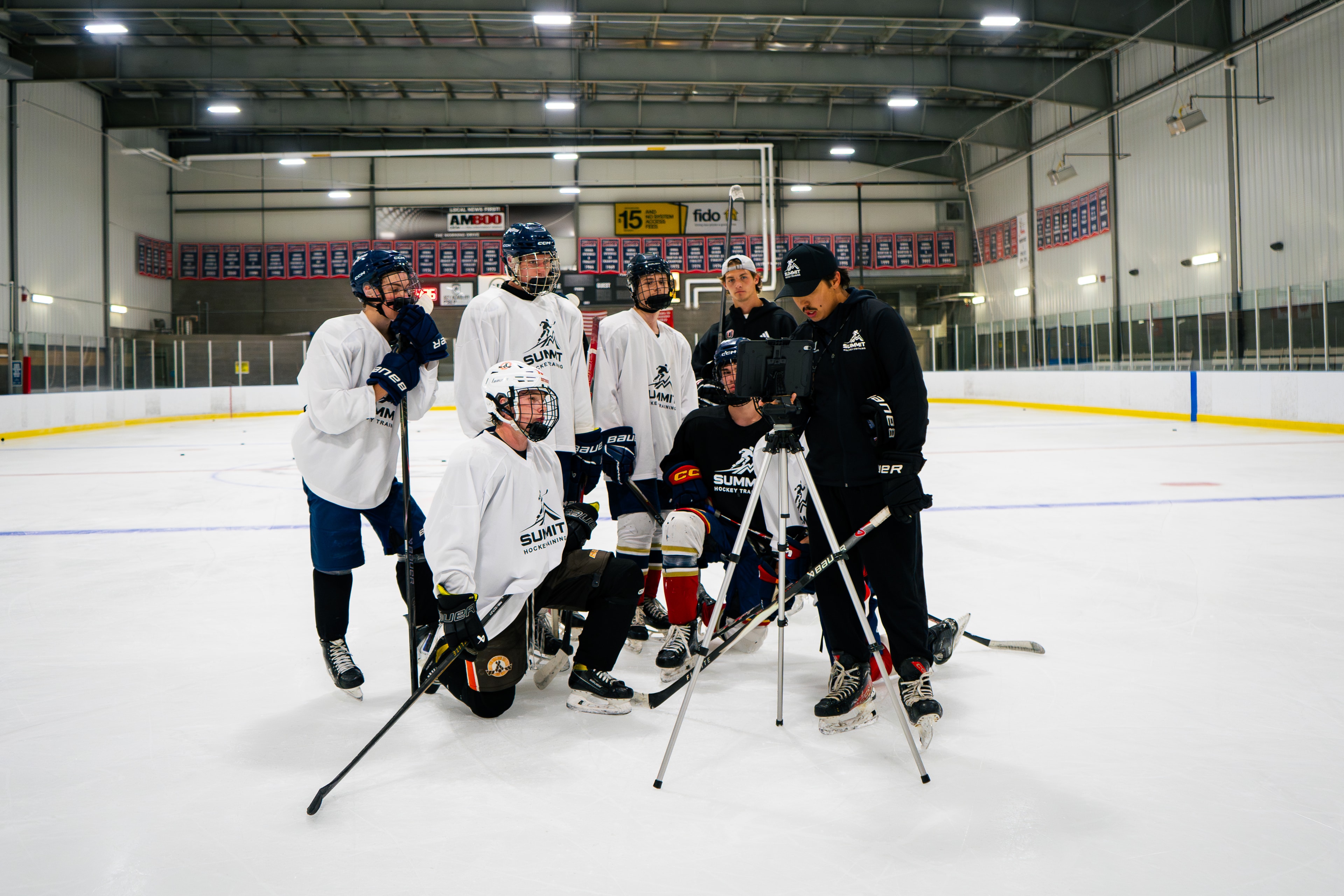 Summit Hockey players reviewing on-ice video with their coach