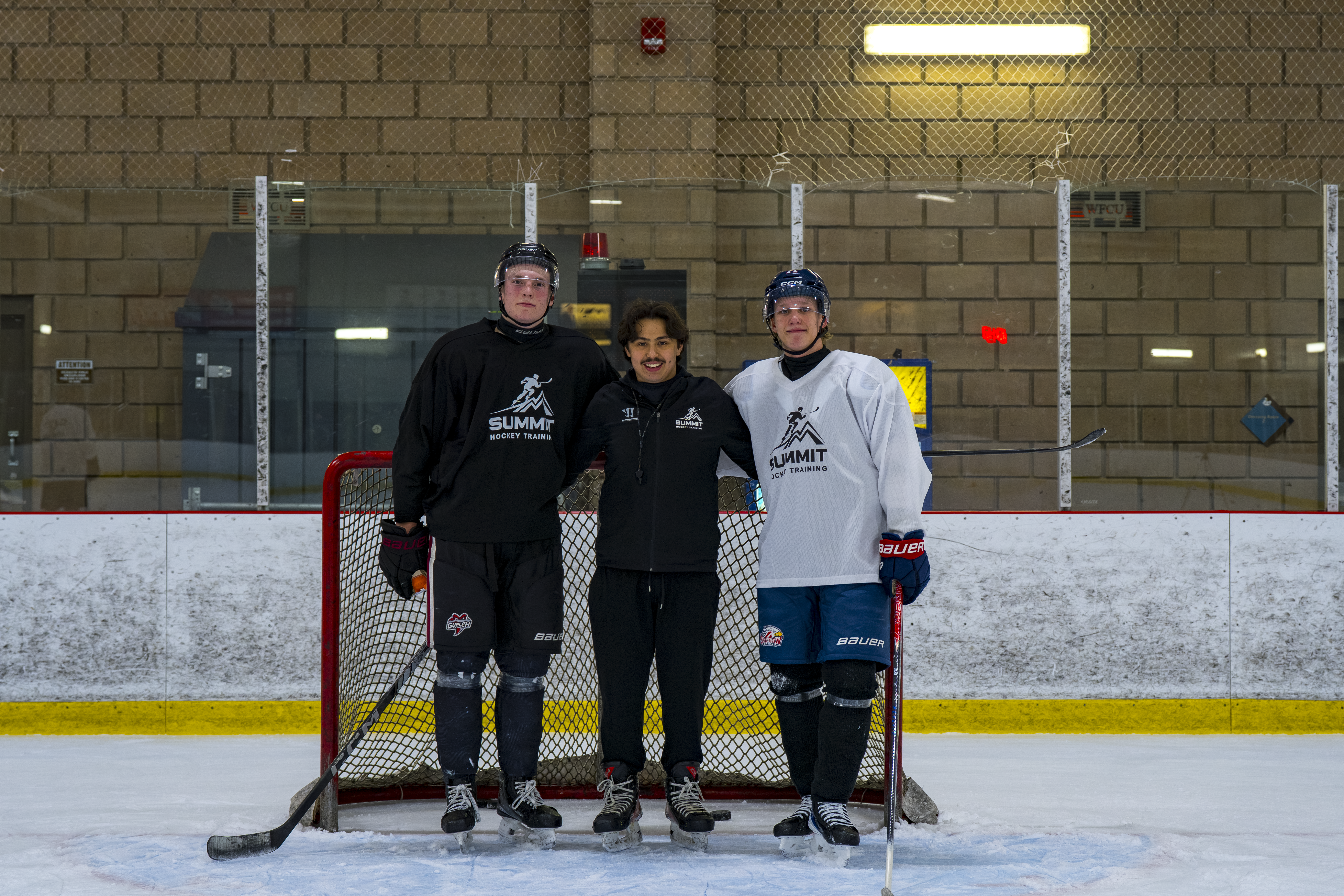 Summit Hockey coach with two players on the ice